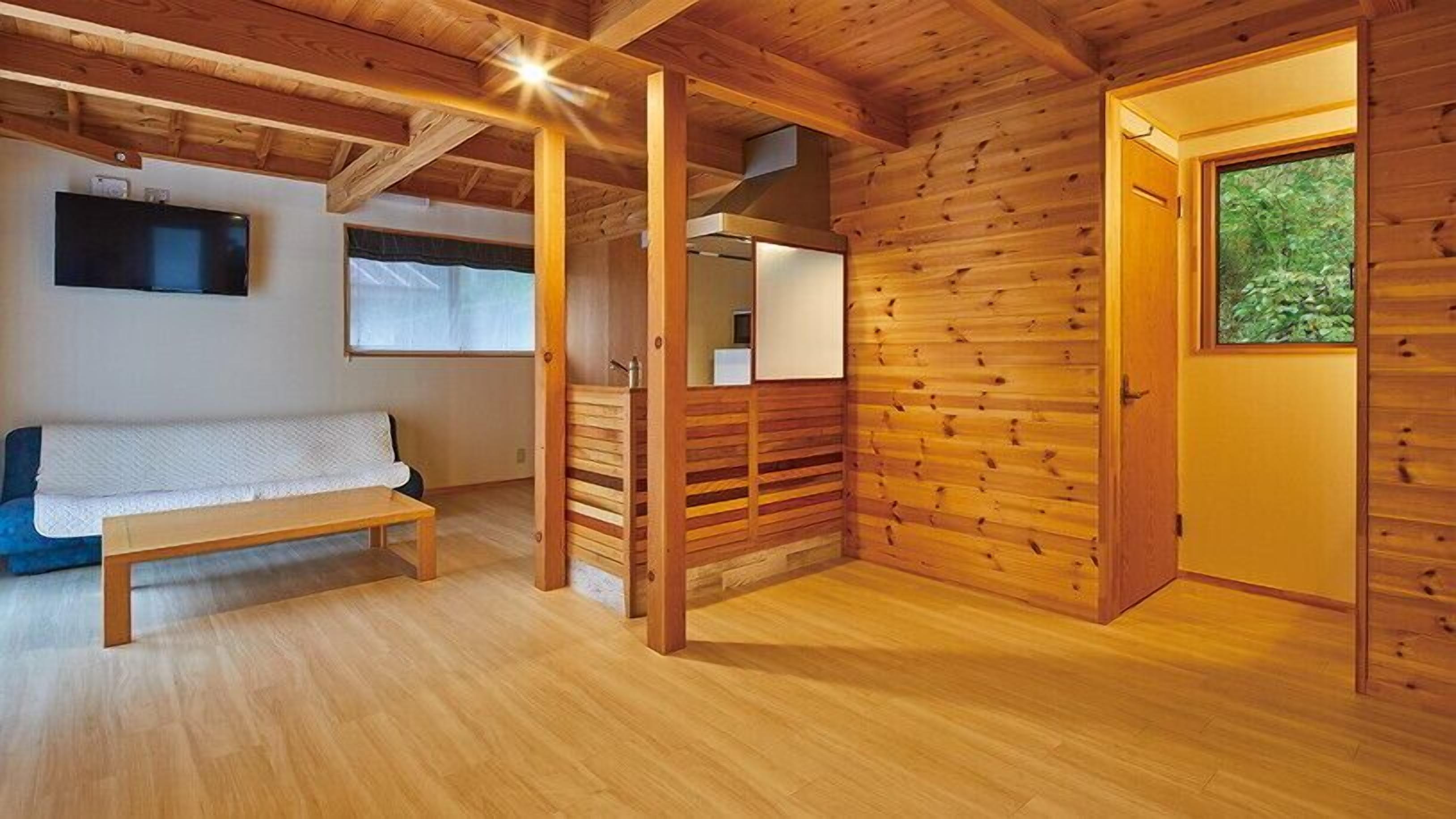 A wooden interior with a bench, a door, and a window.