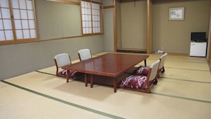 Een traditionele Japanse kamer met tatami vloeren, een houten tafel en vier stoelen van tatami matten.