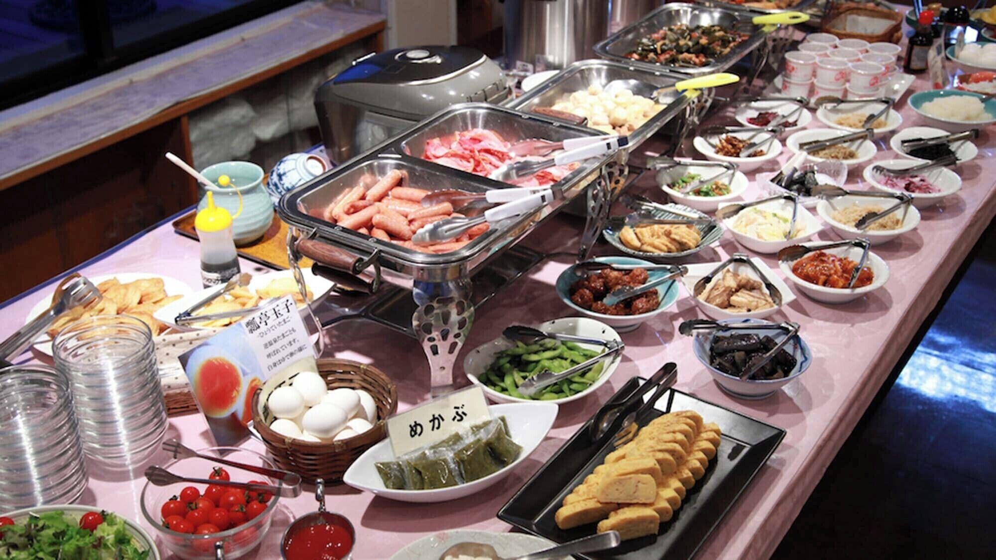 A buffet with various food items and utensils.