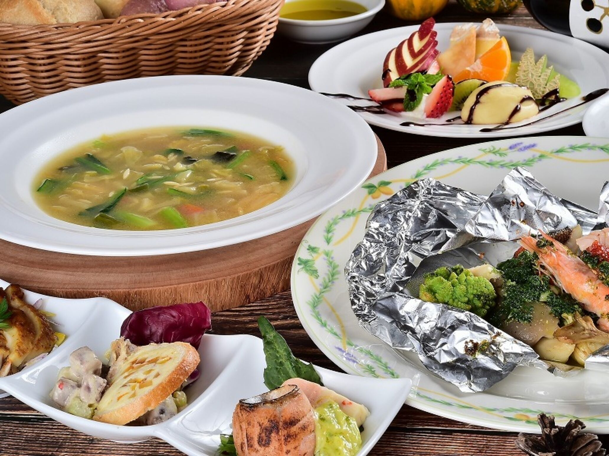 Verschiedene Speisen, darunter Suppe, Meeresfrüchte und Gemüse, auf einem Holztisch.