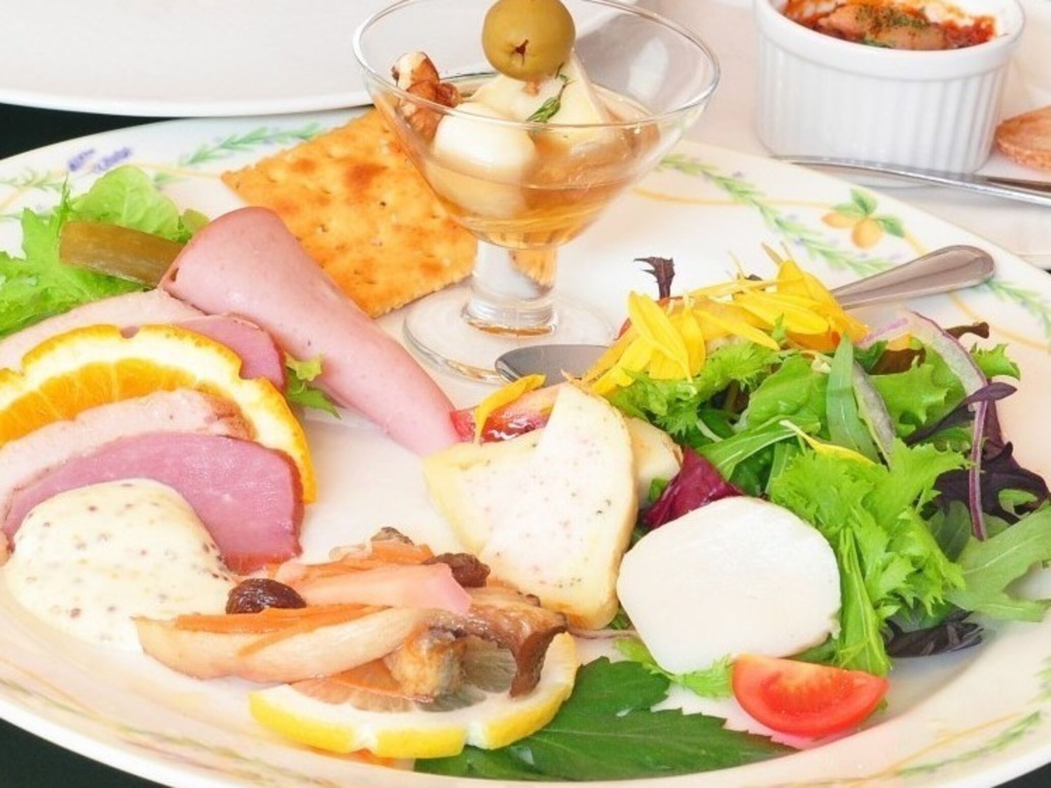 A plate with various food items including sliced meats, cheese, and a salad.