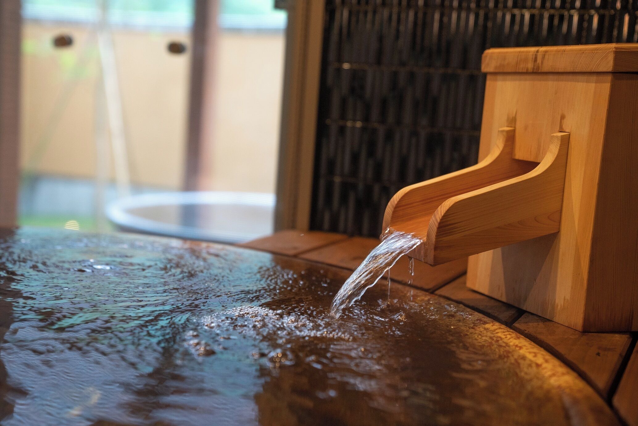 Una fuente de madera con un caño, rodeada de un piso de azulejos.