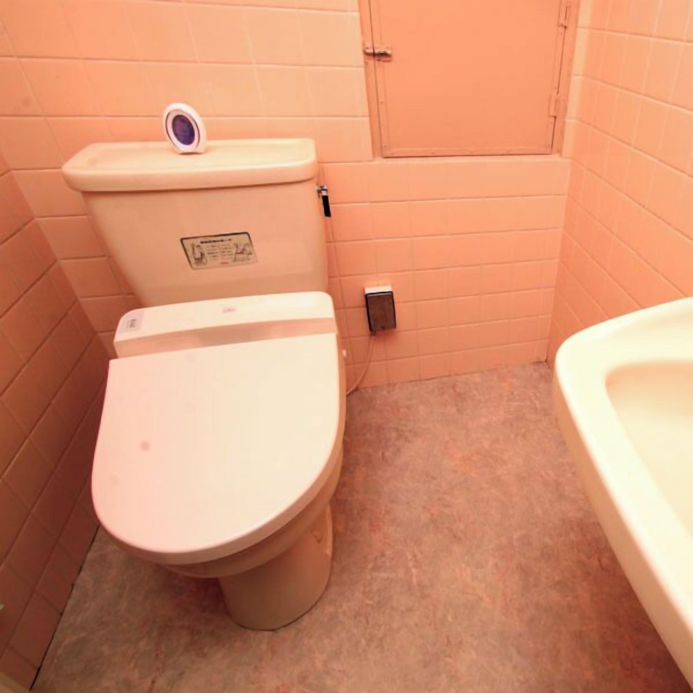 Une petite salle de bain avec des toilettes, un lavabo et un meuble de rangement.