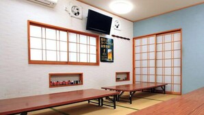 A traditional Japanese room with tatami flooring, a long wooden table, and sliding doors. - Tsushima no Kyodo wo Tanoshimu Ryokan Banshokaku (Tsushima)