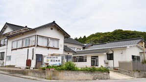 A traditional Japanese building with a sign indicating a ryokan. - Rokko Ryokan (Suzu)