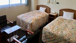 A hotel room with two beds, a desk, a chair, and a window with curtains. - Business Hotel Irieso (Goto)
