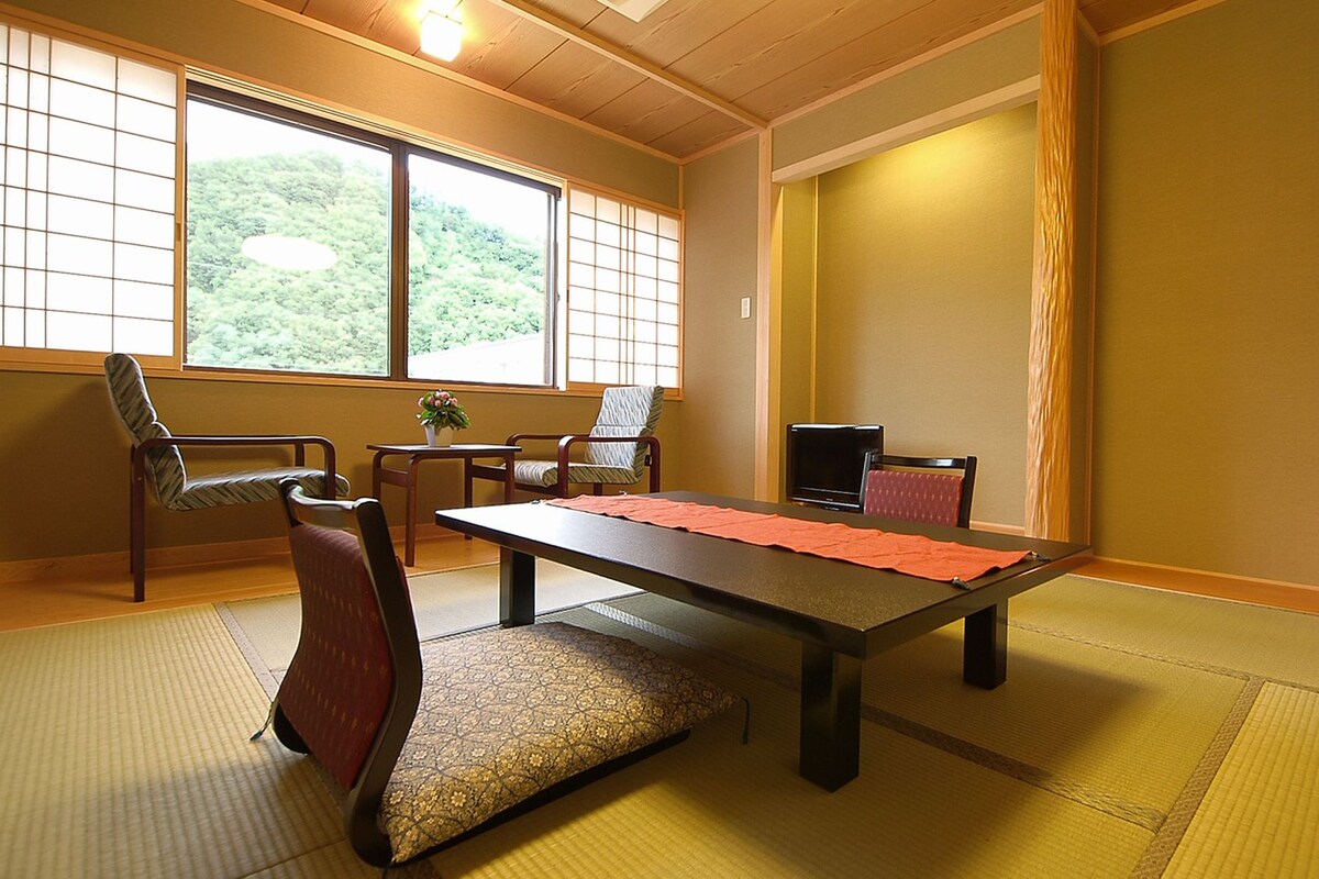 A traditional Japanese room with tatami flooring, a low table, and shoji screens.