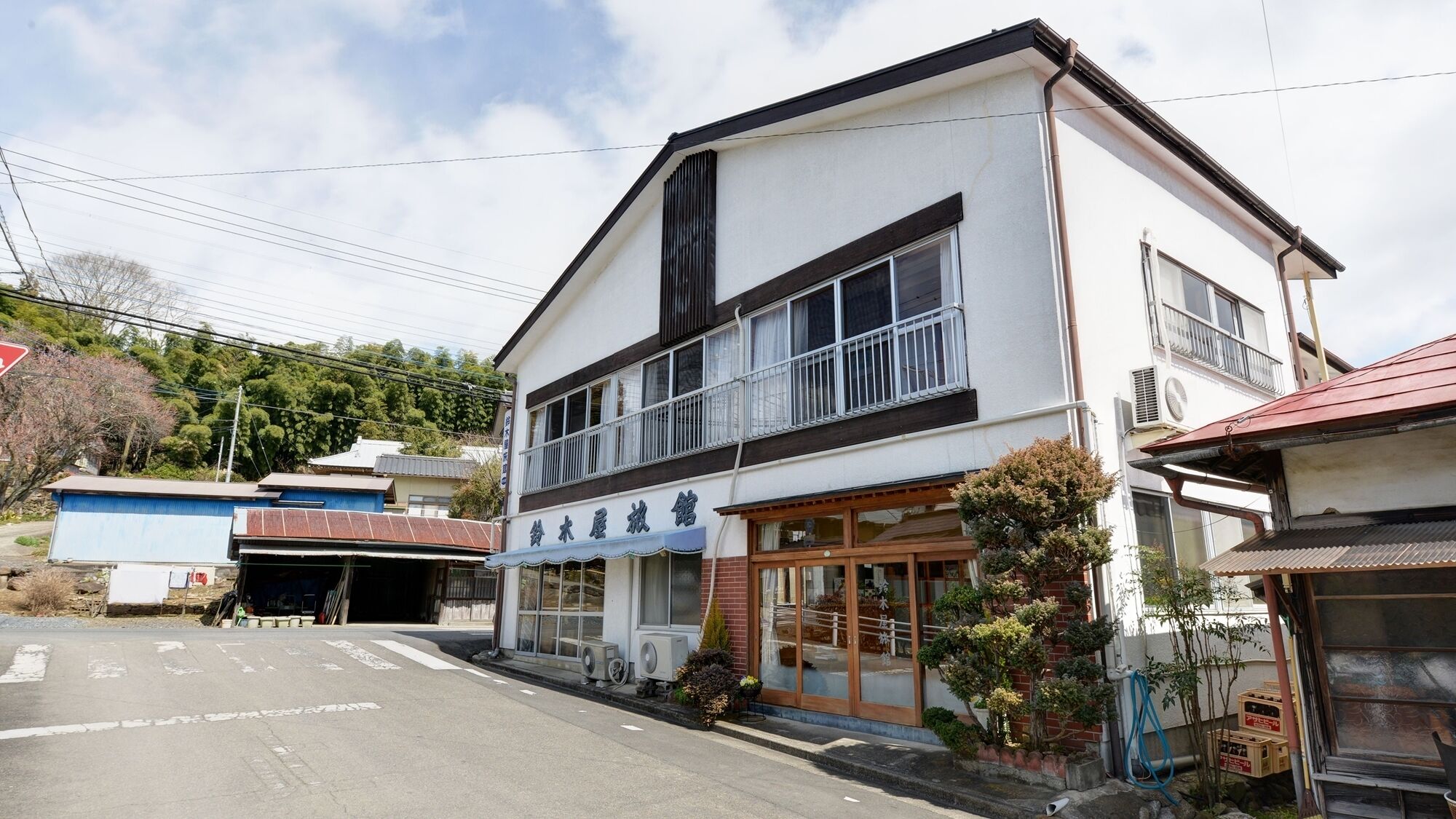 A two-story building with a large window and a balcony on the upper floor.