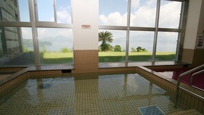 A swimming pool with tiled flooring, large windows with a view of a lake and mountains, and a tiled wall. - Green Stay Nagaura (Suooshima)