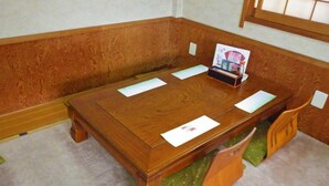 Una taula de conferències de fusta amb papers i una petita caixa al centre.