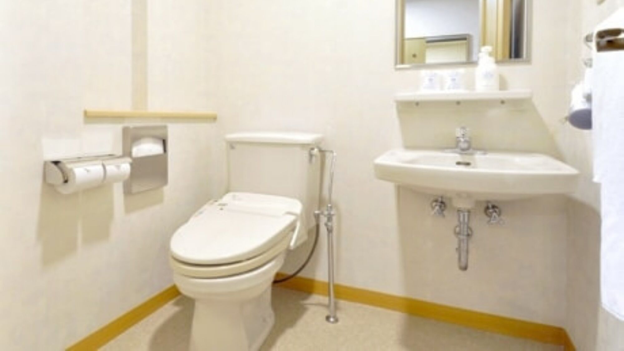 Un baño pequeño y limpio, con inodoro, lavamanos y espejo.