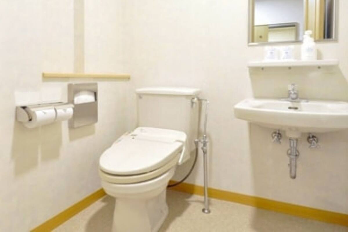 Un baño pequeño y limpio, con inodoro, lavamanos y espejo.