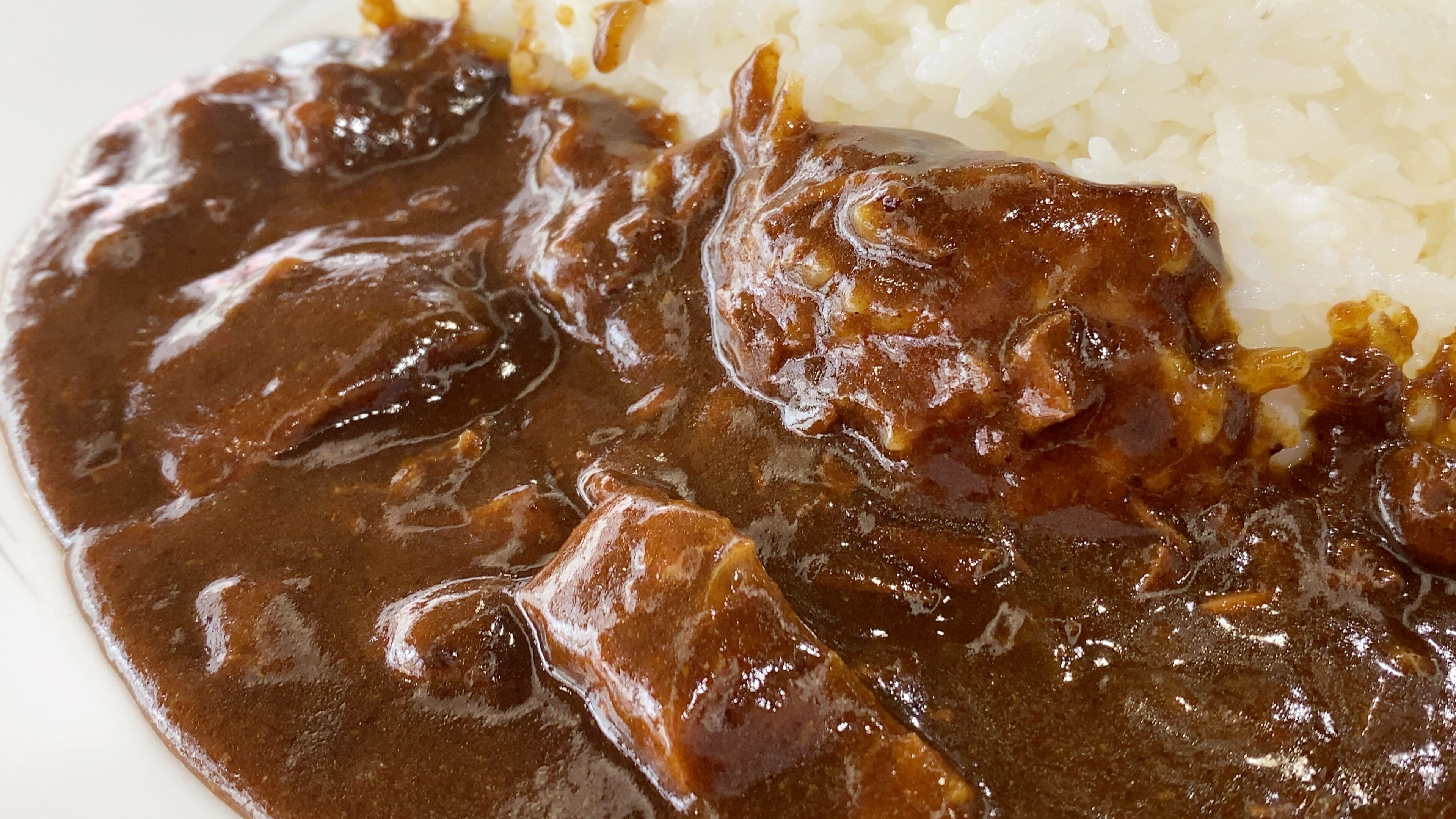 Une assiette de nourriture avec une sauce foncée et du riz.