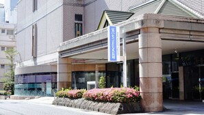 A hotel entrance with a stone facade, a signboard, and a flower bed. - Hotel Saint Hill Nagasaki (Nagasaki)