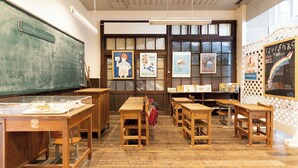 A classroom with wooden desks, a blackboard, and educational posters on the walls. - Hotel Saint Hill Nagasaki (Nagasaki)