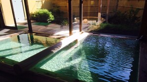 A glass-enclosed pool with clear water, surrounded by a wooden deck and a bamboo fence. - Tokurakamiyamada Onsen Yu No Yado Fukujuso (Chikuma)