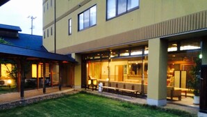 A building with a covered outdoor seating area, a grassy lawn, and a visible entrance. - Tokurakamiyamada Onsen Yu No Yado Fukujuso (Chikuma)