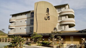 A modern building with a unique curved facade and multiple balconies. - Tsukino Nagisa (Tahara)