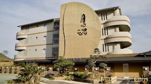 A modern building with a unique curved facade and multiple balconies. - Tsukino Nagisa (Tahara)