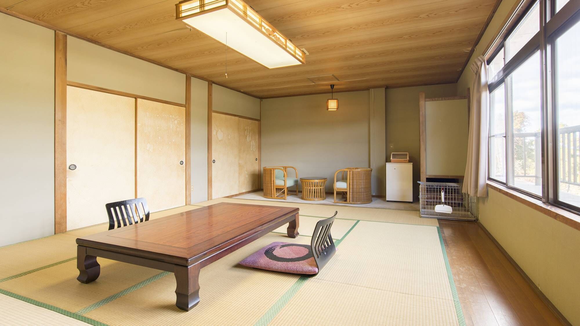 Une pièce de style japonais traditionnel, avec un sol recouvert de tatamis, une table en bois, des chaises, un petit meuble et une fenêtre donnant sur un paysage agréable.