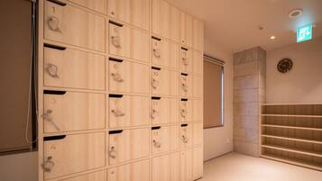 Une chambre d’hôtel avec une grande armoire en bois, une horloge au mur et un escalier.