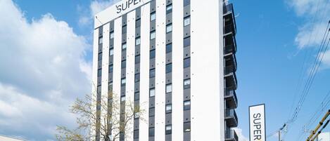 A multi-story hotel building with a prominent sign reading 'SUPERHOTEL' on the facade.