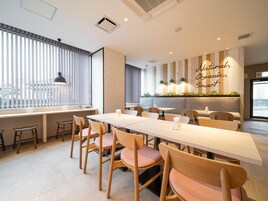 Un comedor moderno con una mesa larga, sillas de madera y una pared con jardín vertical.