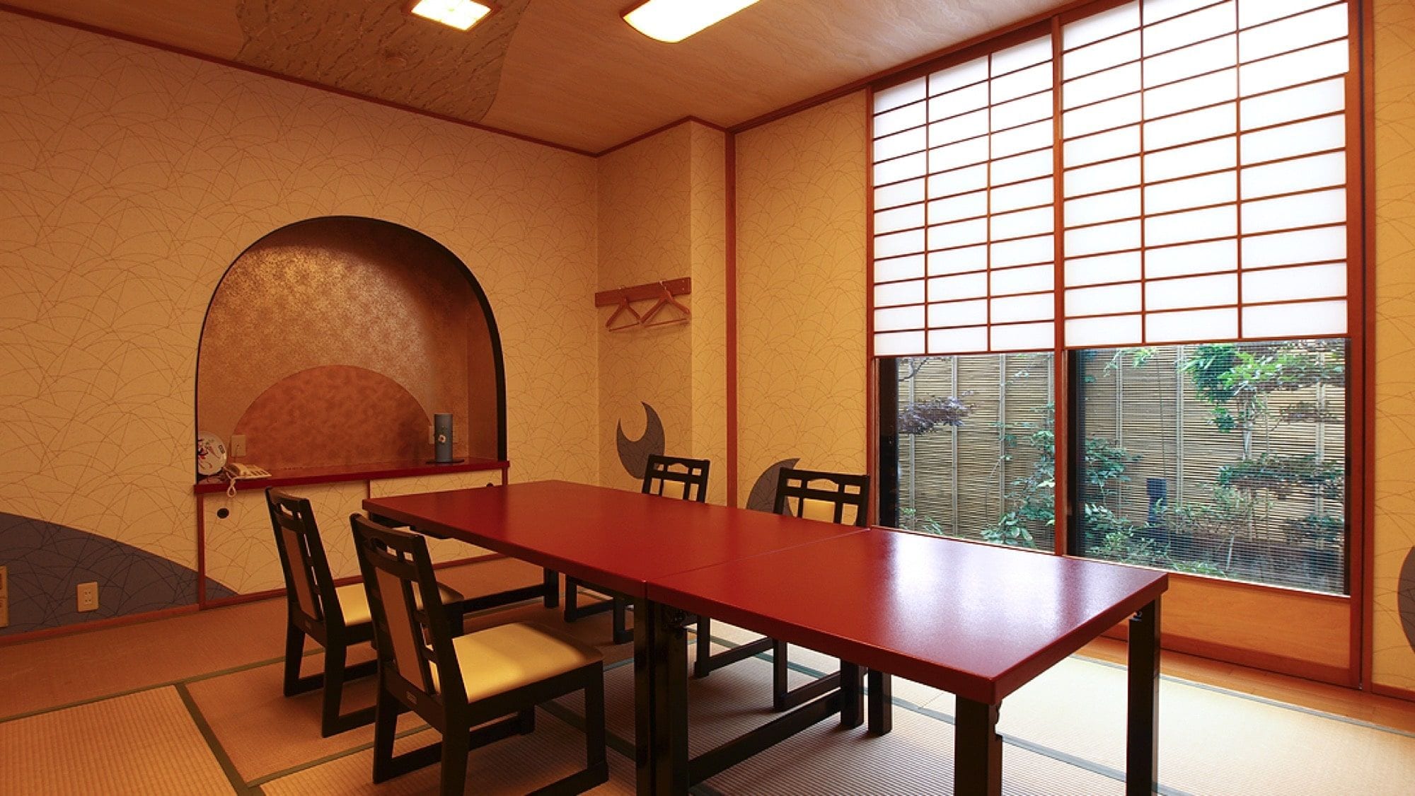 Ein traditioneller japanischer Raum mit Tatami-Bodenbelag, einem niedrigen Tisch und Shoji-Bildschirmen.