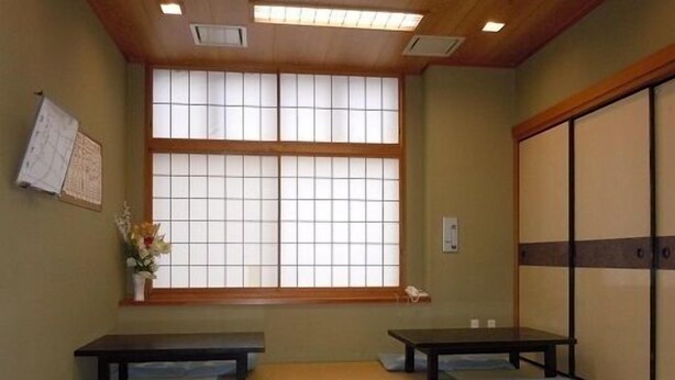 A traditional Japanese room with tatami mats, sliding doors, and a large shoji screen window. - Sunrise Hotel (Ryugasaki)