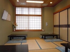 A traditional Japanese room with tatami mats, sliding doors, and a large shoji screen window. - Sunrise Hotel (Ryugasaki)
