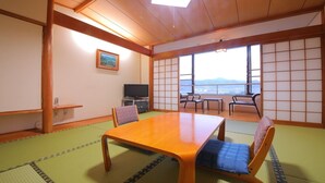 A traditional Japanese room with tatami flooring, a wooden table, and shoji screens. - Wellpia Iyo (Iyo)