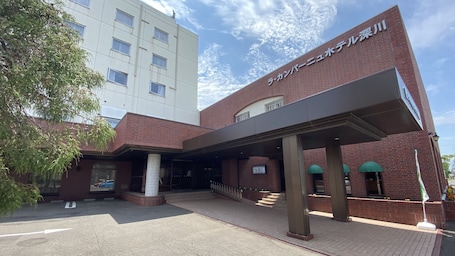 A building with a brick facade, a covered entrance, and a sign in a foreign language.