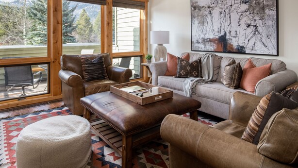 A cozy living room with leather furniture, a large window, and a mountain view. - Outpost: Windflower 2115 - Mountain Views! (Wilson)