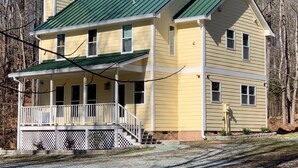 A two-story house with a green roof and a covered porch. - Farmhouse Retreat (Rougemont)