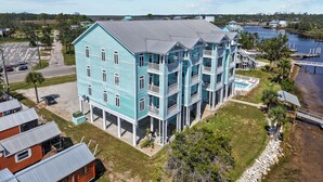 A multi-story building with balconies, located near a body of water.