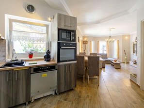 Een koelkast, een oven, kookgerei, borden en bestek, een vriezer