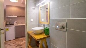 A modern bathroom with a large mirror, a vessel sink, and a wooden stool. - Immaculate 1-Bed House in Zakynthos (Zakynthos)