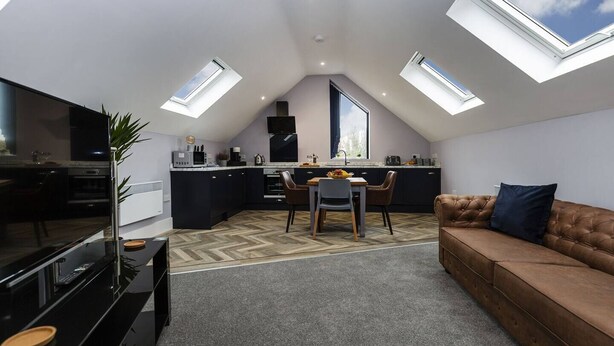 Un moderno loft con cucina, zona pranzo e soggiorno.