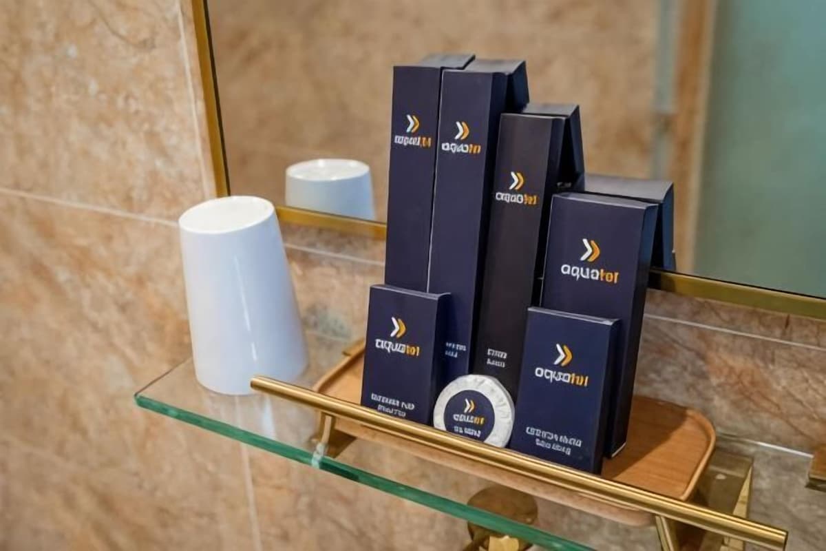 A display of Aquafor products on a glass shelf in a bathroom.