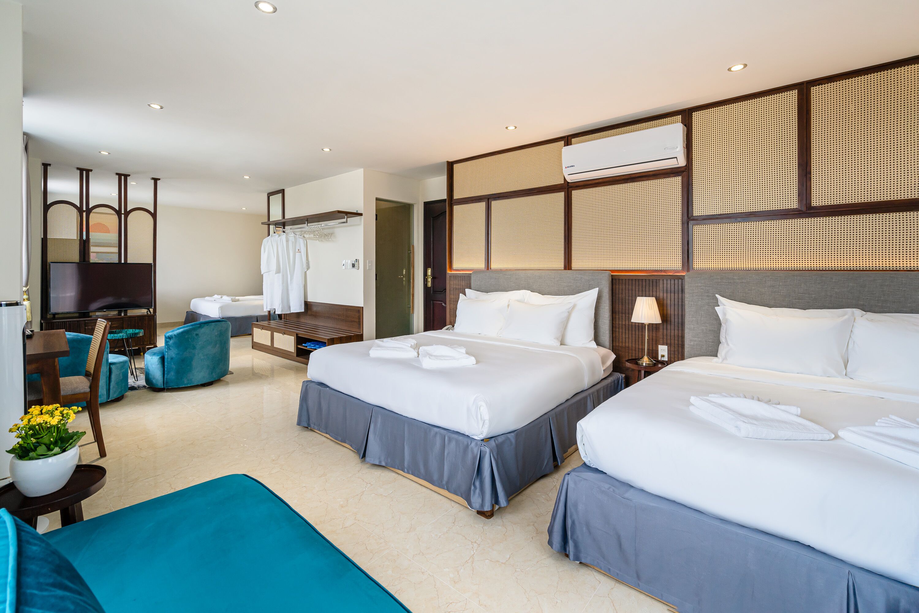 Habitación de hotel con dos camas, televisión, escritorio y zona de estar.