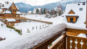 A snowy mountain village with wooden houses and a wooden deck. - Lipki Park Resort by Interhome (Zakopane)
