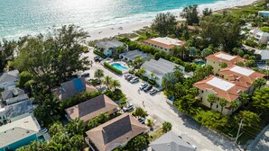 An aerial view of a coastal residential area with houses, a swimming pool, and a beach. - Beach Condo with Pool Near Holmes Beach! (Holmes Beach)