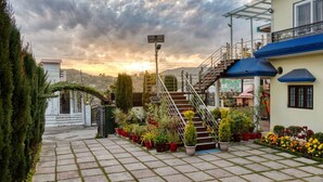 A building with a sign for Walnut Creek Restaurant, a staircase, and potted plants. - Hotel Walnut Creek (Nainital)