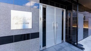 A hotel entrance with a signboard, double doors, and a tiled facade. - Fancy (Sapporo)