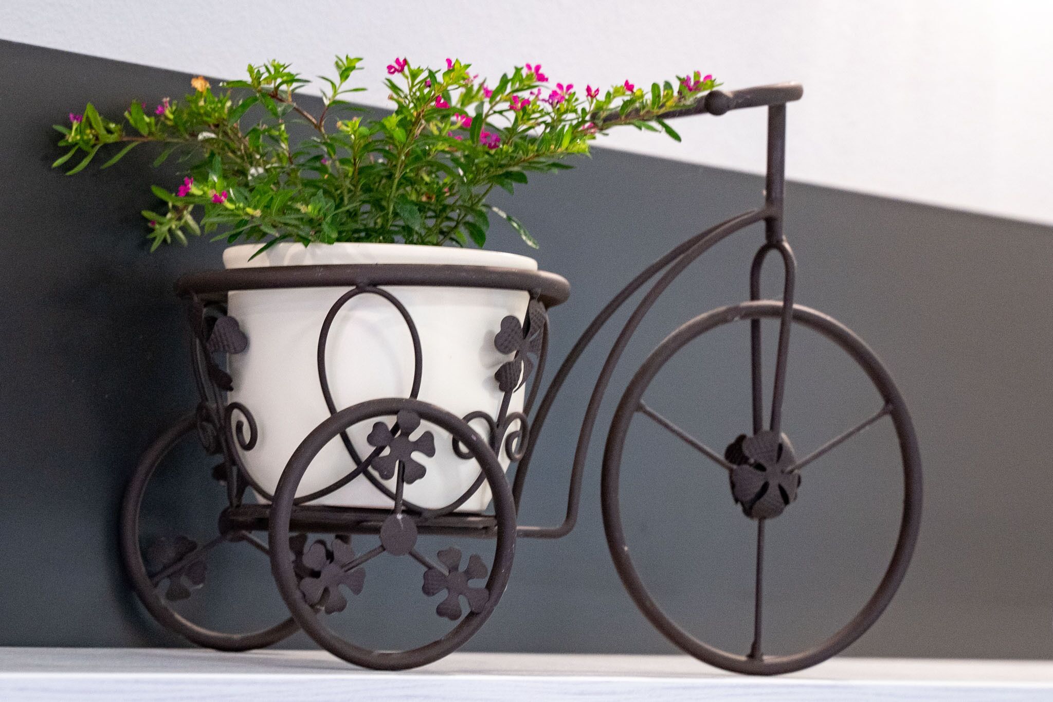 A stationary bicycle planter with flowers.