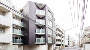 A modern multi-story building with balconies and a flat facade. - Eve (Sapporo)