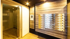 A modern elevator with a metallic finish and a control panel. - Eve (Sapporo)