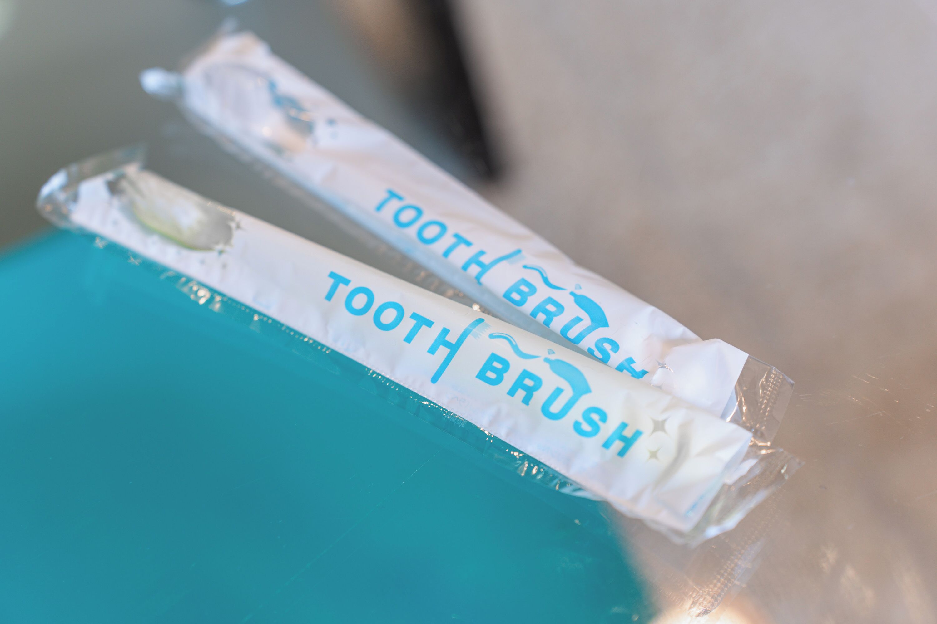 Primer pla de dues escobes de dents embolicales amb el text "TOOTH BRUSH".