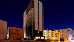 Un edificio de gran altura con varios pisos, presumiblemente un hotel o complejo de apartamentos, con un diseño arquitectónico moderno.