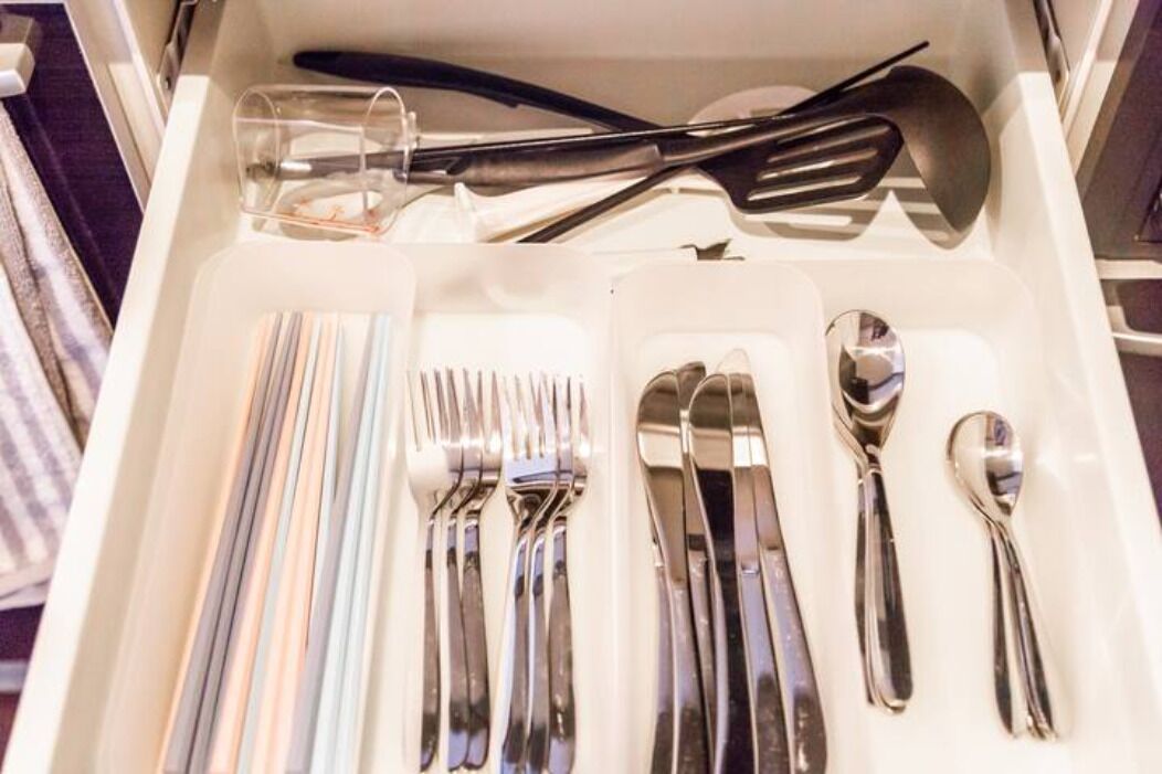 A drawer containing neatly arranged silverware including forks, knives, and spoons.